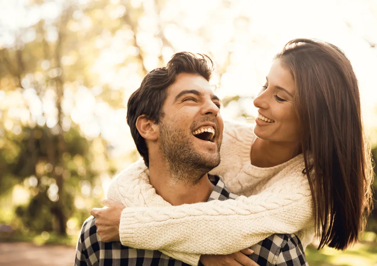 Young couple laughing, piggyback ride