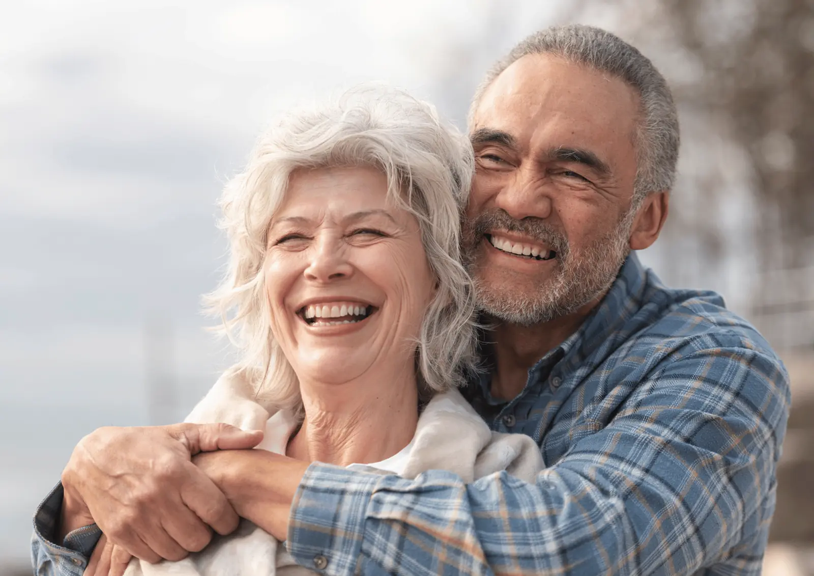 Older couple laughing in an embrace